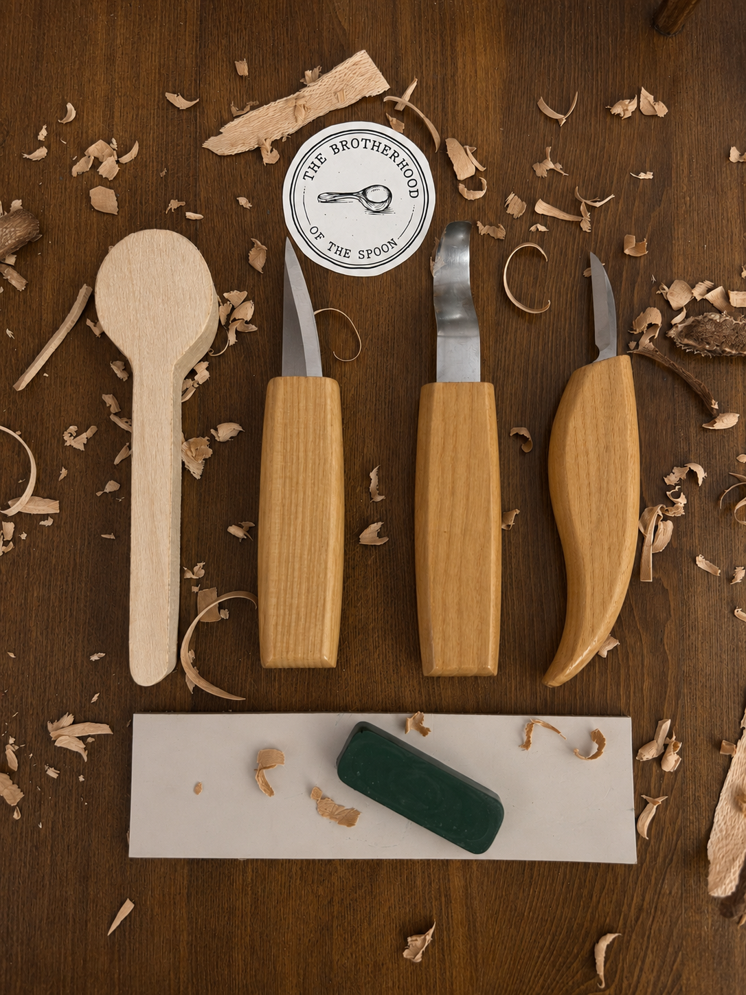 Woodworking tools on a wooden surface with 'The Brotherhood of the Spoon' logo.